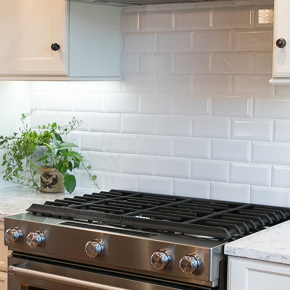 detail of modern stove range with white subway tile.